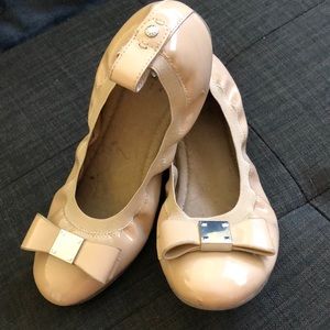Slightly worn tan patent leather flats.